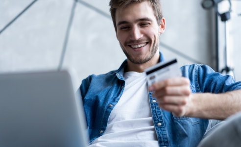 guy using laptop with credit card